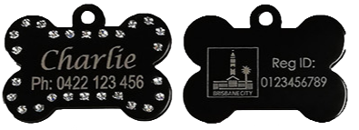 A black, bone-shaped pet tag with rhinestones around the edges. The front side reads: "Charlie Ph: 0422 123 456." The back side features an engraving of a building with "BRISBANE CITY" below it and "Reg ID: 0123456789.