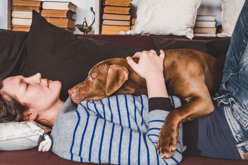 person with disabilities feeling ill with a dog on their chest for comfort