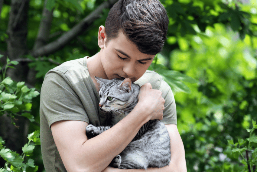 emotional support animal, emotional support cat being held by a young male