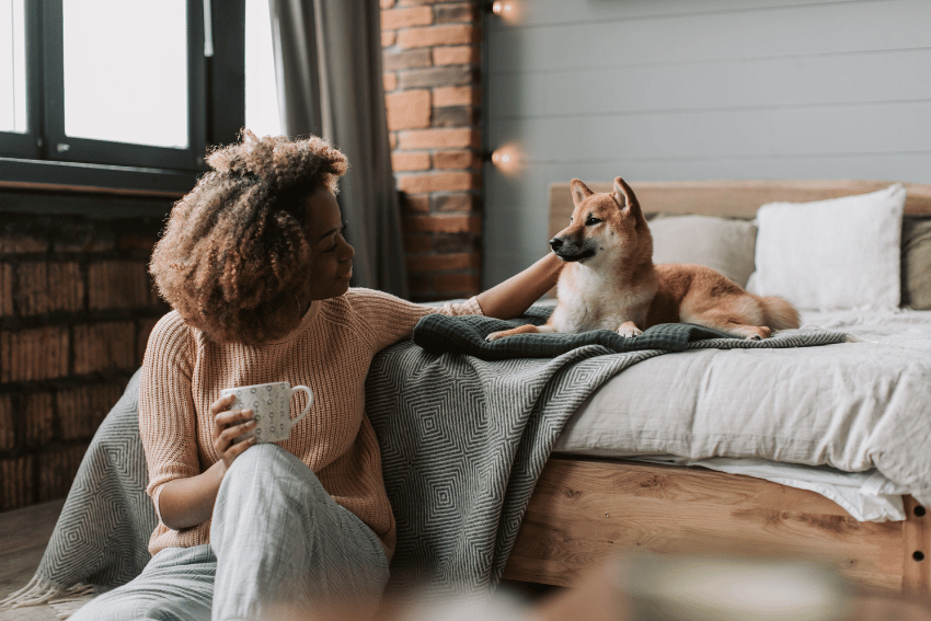 Woman with Shiba Inu dog on bed