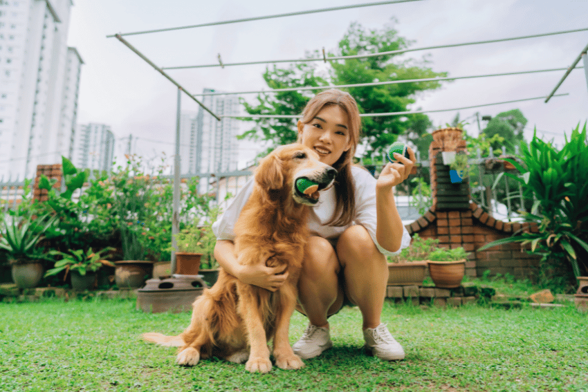 Woman with golden retriever in garden