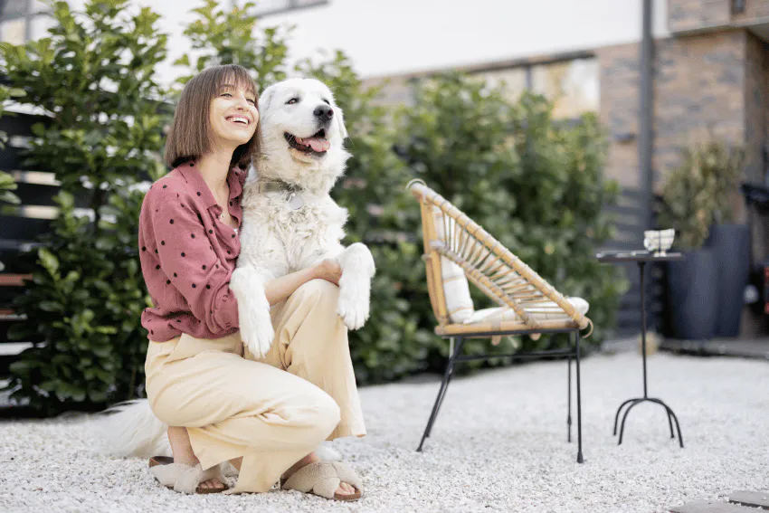 Woman with white dog in backyard